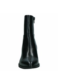 Botín de cuero negro hasta el tobillo con un acabado suave, puntera afinada y cremallera lateral para el cierre. Suela de goma plana y diseño minimalista.