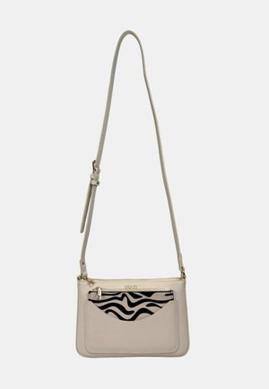 Beige Umhängetasche mit verstellbarem Riemen, vorn mit einer schwarz-weißen Zebra-Print-Tasche und goldfarbenen Beschlägen.