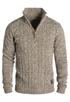 Brown cable-knit sweater with a zip neck, ribbed cuffs and hem, featuring textured yarn and a small leather logo patch on the bottom.