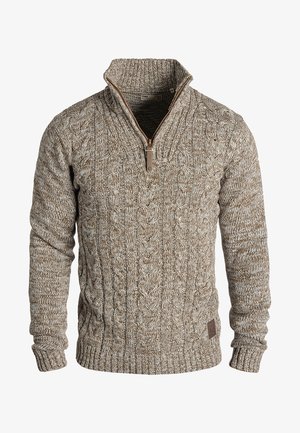 Brown cable-knit sweater with a zip neck, ribbed cuffs and hem, featuring textured yarn and a small leather logo patch on the bottom.