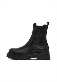 Stivale Chelsea in pelle nera con pannelli elastici laterali, punta rotonda e suola in gomma testurizzata. Presenta una linguetta sul retro.