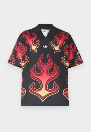 Fekete hálós sportpóló nagy piros és sárga lángmintákkal, az Adidas fehér logójával, amely a gallér alatt középen helyezkedik el.