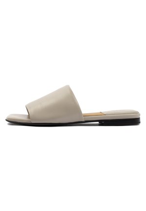 Beige leather slide sandals with an open toe, featuring a wide band across the foot and a flat black sole.