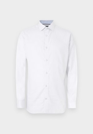 Άσπρο μακρυμάνικο πουκάμισο από βαμβάκι με διακριτική υφή, γιακά με κουμπιά και μπλε λεπτομέρεια στο εσωτερικό του γιακά. Κανονική γραμμή εφαρμογής.