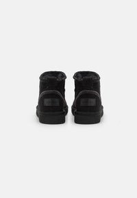 Μαύρες σουέτ μπότες μέχρι τον αστράγαλο με μαλακή επένδυση, θηλιά για εύκολη φορεσιά και διακοσμητική ραφή στο πίσω μέρος. Πλακέ καουτσούκ σόλα για πρόσφυση.