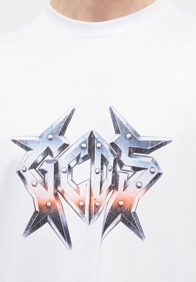 Λευκό πουκάμισο με μεταλλικό, βιομηχανικού στιλ σχέδιο που σχηματίζει το "GCDS" με αιχμηρά, ζωσμένα γράμματα και πορτοκαλί διαβαθμισμένες αποχρώσεις.