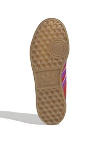 Podeszwa gumowego trampka o fakturze plastra miodu. Zawiera okrągłe wgłębienie i logo. Kolor: jasnobrązowy, z czerwonymi i fioletowymi akcentami.