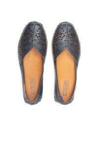 Blaue Lederflats mit lasergefrästem Blumenmuster, mandelförmiger Zehenbereich und beigem Fußbett. Mit geflochtenem Rand für zusätzliche Details.