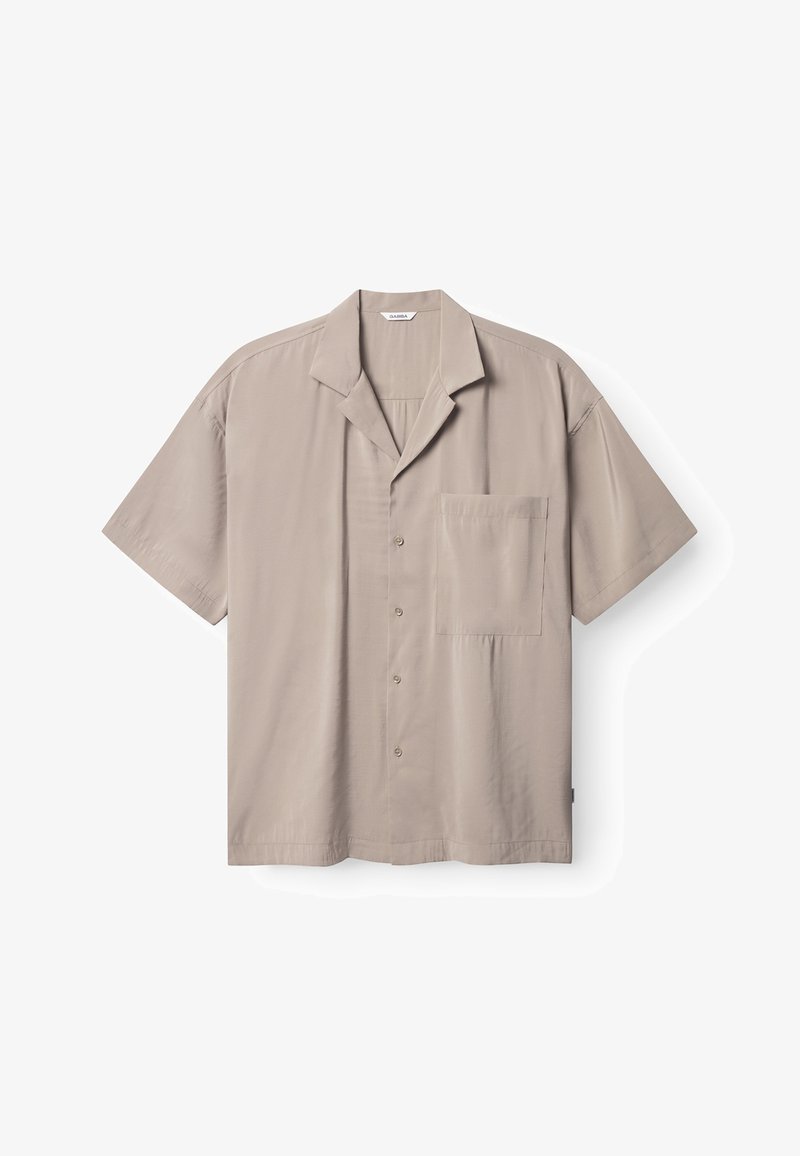 Kortärmad skjorta med knappar i ljusbeige tyg, med slät textur, uppvikbar krage och en enkel bröstficka.