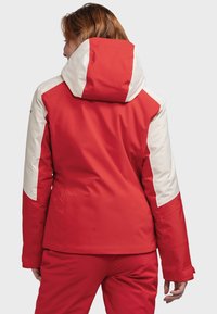 Red and white waterproof jacket with a hood, featuring color-block design, long sleeves, and smooth texture.