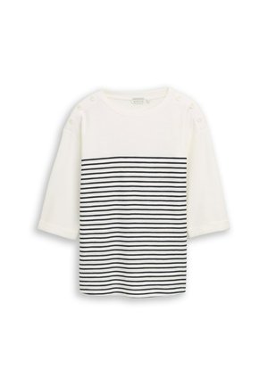 Camicia bianca a maniche lunghe con righe orizzontali nere nella metà inferiore e bottoni sulle cuciture delle spalle, mostrata stesa su uno sfondo bianco.