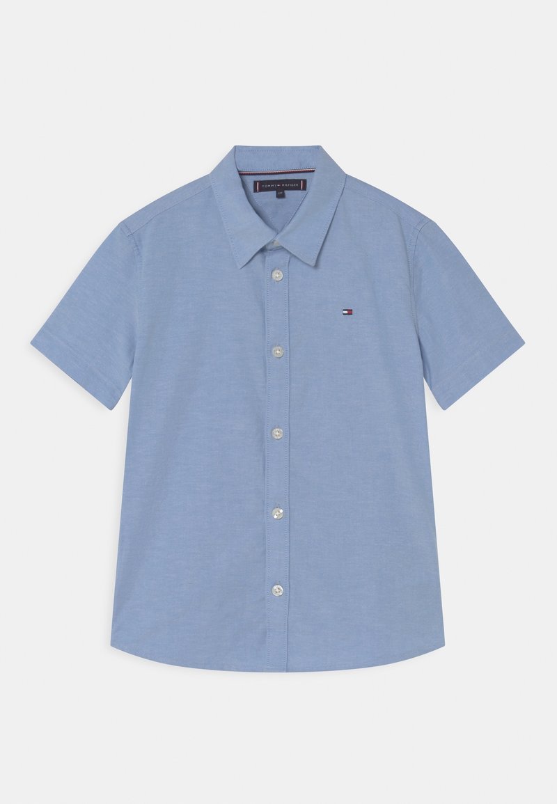Kurzärmeliges Hemd aus leichtblauem Baumwollstoff mit spitzem Kragen und kleinem Logo auf der Brust. Verfügt über einen geraden Saum und Knöpfe.