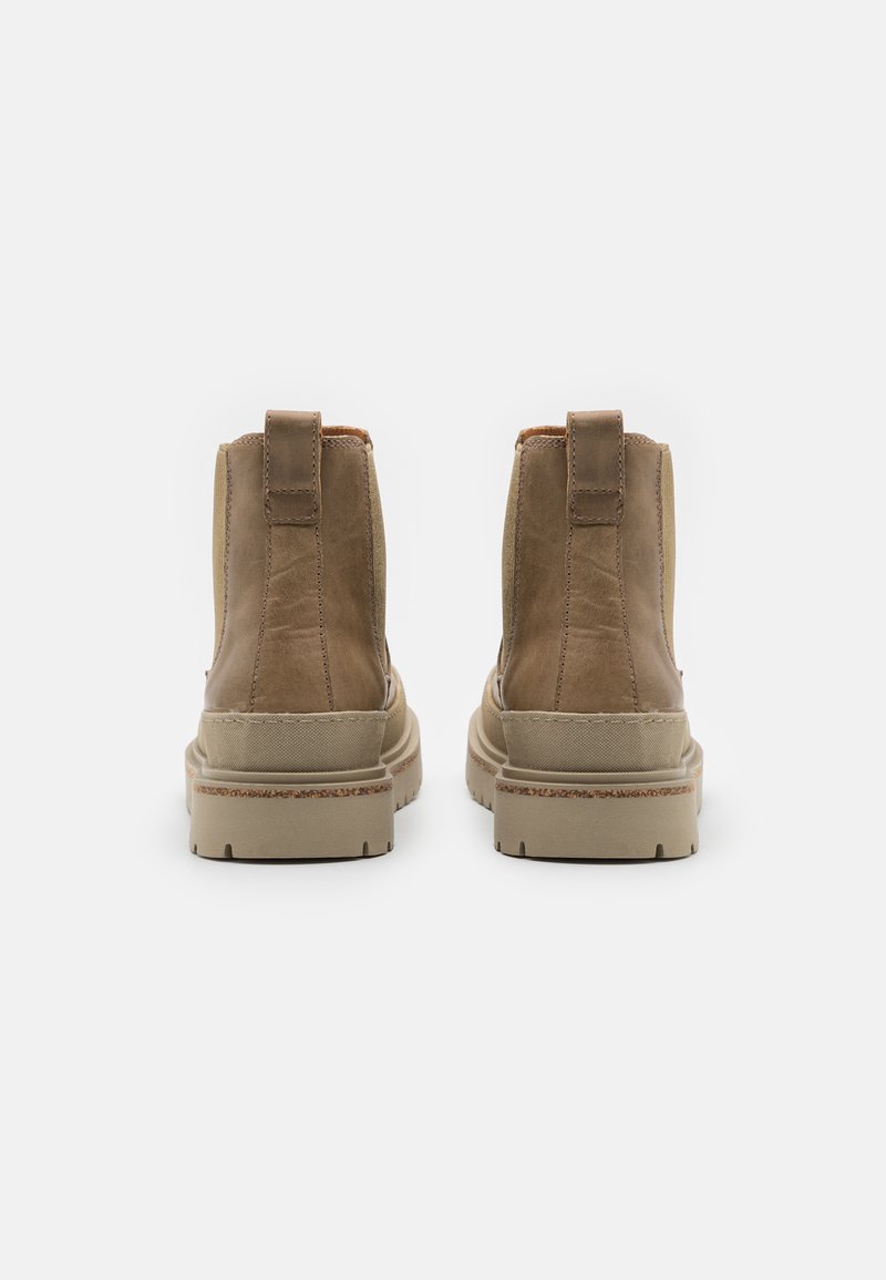 Stivaletti in pelle marrone con una morbida texture, pannelli laterali elasticizzati e una robusta suola in gomma beige. Anelli di rinforzo sul tallone per una facile vestibilità.