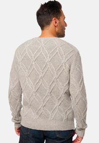 Pull en tricot gris avec un motif en diamant texturé, col rond et ourlet côtelé. Il dispose de manches longues et d'une coupe décontractée.