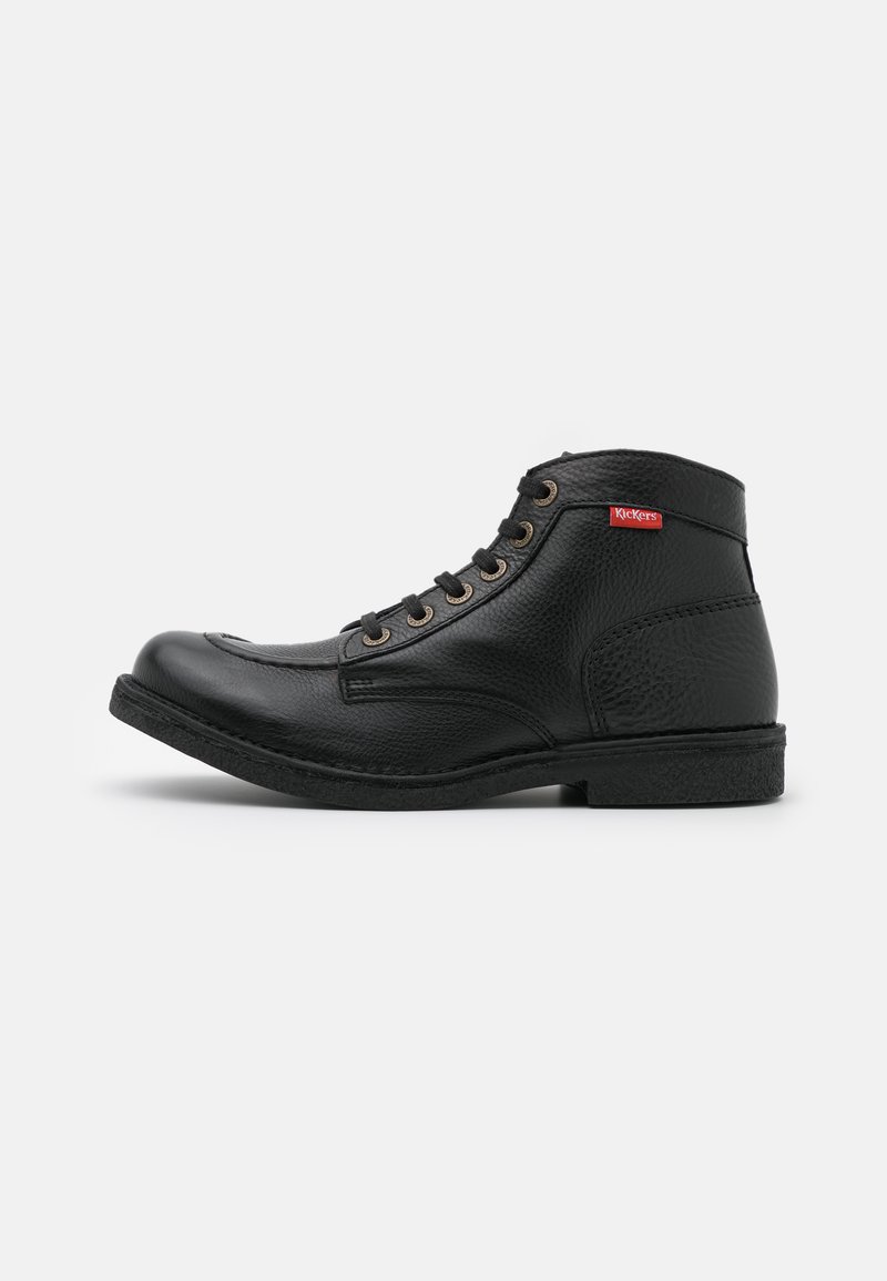 Zwarte leren enkellaarsjes met textuur, metalen oogjes en een rood Kickers-logo. Rond puntje en platte rubberen zool.