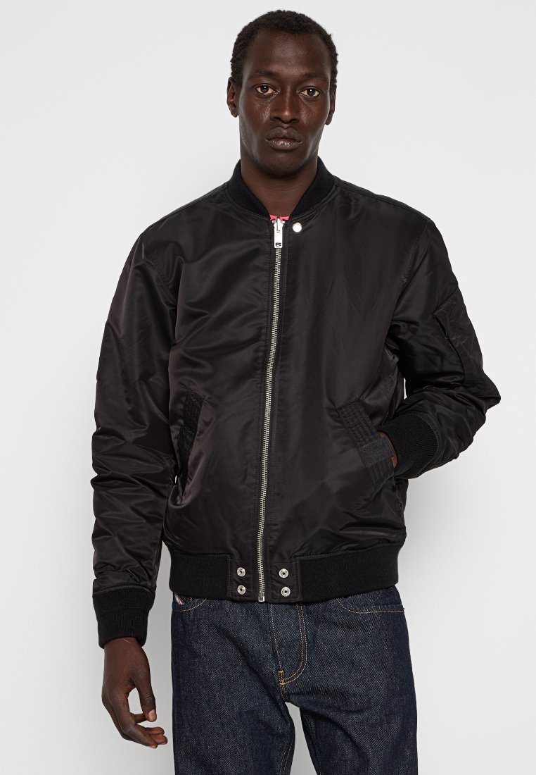 Veste bomber noire avec une finition satinée brillante, fermeture éclair à l'avant, deux poches latérales, poignets et ourlet côtelés, arborant un design classique.