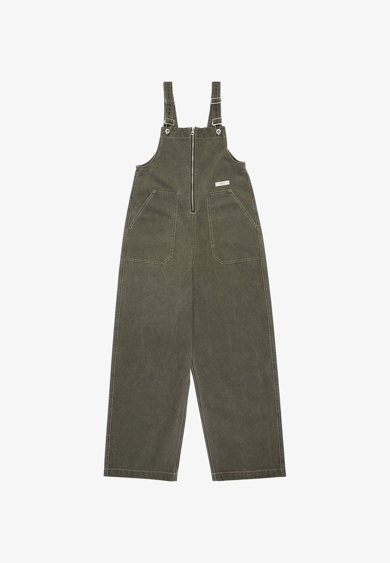 Olive green cotton overalls with adjustable straps, front zipper closure, and two large front pockets. Wide-leg fit with stitching details.