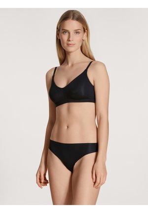 Zwarte beha en bijpassende bikini slip gemaakt van glad, rekbaar materiaal. De beha heeft dunne verstelbare bandjes en een V-hals ontwerp.