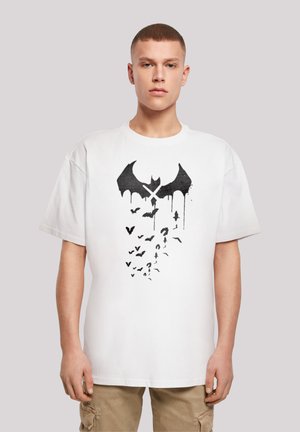 White short-sleeve t-shirt featuring a black bat and flying bats graphic with drips. Crew neck design, casual fit, soft fabric texture.