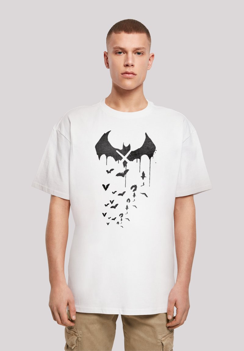 Balta trumpa rankovė t-shirt marškinėliai su juodu šikšnosparniu ir skraidančių šikšnosparnių grafika su lašais. Apvalus kaklas, laisvas kirpimas, minkšta audinio tekstūra.