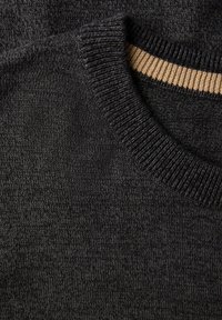 Grauer Strickpullover mit einem gerippten Kragen mit einem kontrastierenden beigen Streifen, der eine weiche Textur zeigt und einen Nahansicht des Stoffs präsentiert.