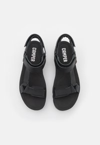 Svarta sandaler med justerbara remmar, strukturerad fotbädd och Camper-logotyp på innersulorna. Platt sula med en säker passform.