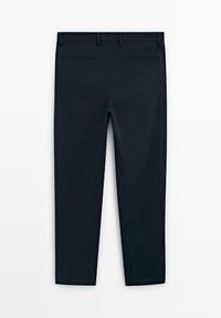 Tmavě modré kalhoty s úzkým střihem, které mají hladkou texturu, dvě zadní kapsy a čistý pas s poutky na opasek.