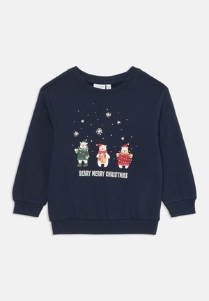 Granatowa bluza dziecięca z trzema kreskówkowymi niedźwiadkami ubranymi w zimowe ubrania, z płatkami śniegu nad nimi oraz napisem „Beary Merry Christmas” poniżej.