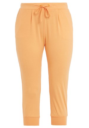 Pantaloni jogger de culoare piersică, confecționați dintr-un material moale, cu un brâu elastic și șnur, și cu tivuri îngustate.