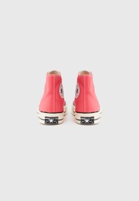 Κόκκινα καμβά ψηλά αθλητικά παπούτσια με λευκές λαστιχένιες σόλες και μαύρες λεπτομέρειες. Διαθέτουν λογότυπο στον αστράγαλο και αντικριστή ραφή.