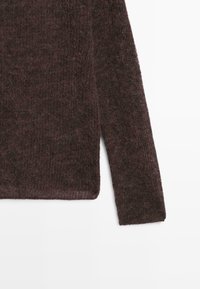 Donkerbruine gebreide trui met een losse, gestructureerde stof en een ontwerp met lange mouwen. De zoom is rechtgesneden met een lichte transparantie.