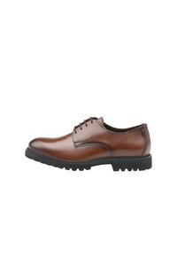 Brązowy skórzany but o gładkim wykończeniu, zaokrąglonym nosku i czarnej gumowej podeszwie z rowkami. Posiada sześć przelotek na sznurowadła.