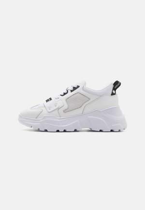 White chunky sneakers with a textured leather upper, mesh accents, black logo detail, and a thick white outsole. Side loop for easy wear.