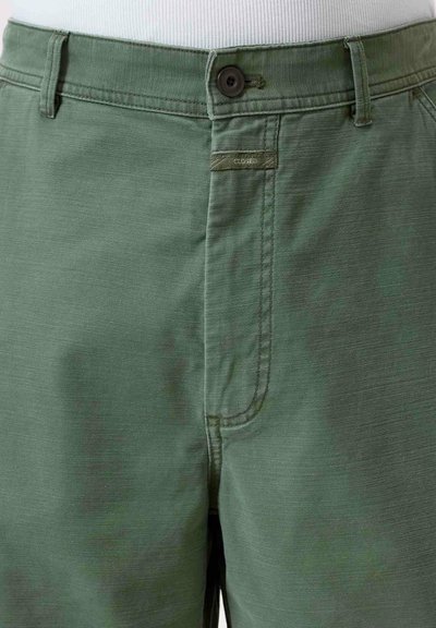 Shorts verde in cotone con chiusura a bottone, tasche laterali e una sottile trama. L'etichetta del marchio è visibile sul davanti.