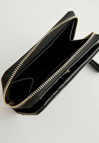 Portefeuille noir à fermeture éclair avec un extérieur texturé et des finitions en métal doré. L'intérieur comprend plusieurs compartiments pour s'organiser.