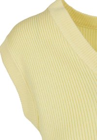 Top de punto acanalado amarillo con escote en V y mangas cortas. La textura es suave, con sutiles rayas verticales en toda su superficie.