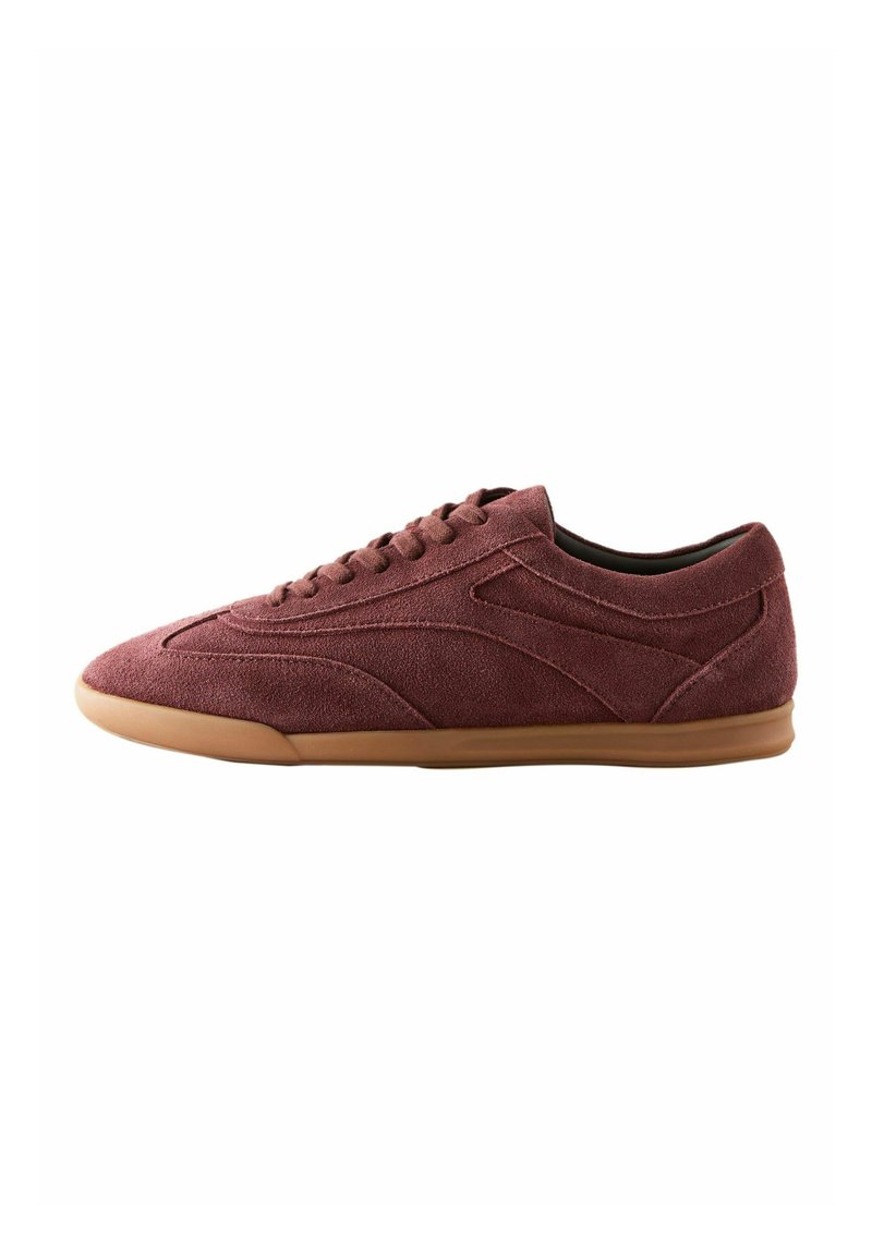 Burgundy suede sneakers with a low-profile design, textured upper, six eyelets, and a gum rubber sole for added grip.