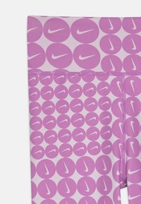 Rosa leggings med gjentagende lilla sirkulære mønstre og Nike-logo i hvitt. Glatt stoff med en elastisk og tettsittende design.