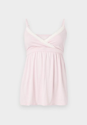 Bez piedurknēm, rozā blūze ar mežģīņu akcentu ap kakla izgriezumu, ar pārklājošu dizainu un saburzītu vidukli, kas veido plūstošu siluetu.