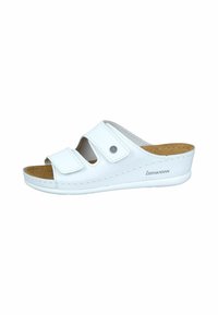 White slide sandal with two adjustable hook-and-loop straps, cork insole, and rubber outsole. Features a rounded toe and slight heel.