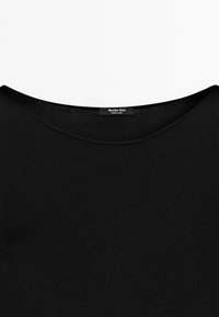 Maglione nero a girocollo esposto piatto su uno sfondo bianco, con un'etichetta che recita "Massimo Dutti."