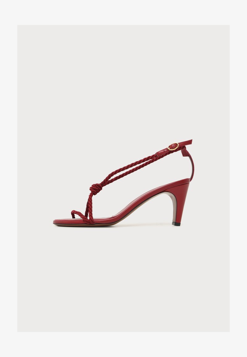 Sandale rouge à talon avec brides en corde torsadée, bout ouvert, boucle à la cheville et petit talon bloc, présentée sur un fond blanc uni.