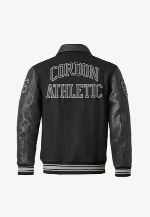 Schwarze Collegejacke mit Lederärmeln, "Cordon Athletic" auf dem Rücken bestickt, gestreifte Rippbündchen und Saum. Nummer "86" auf dem linken Ärmel.