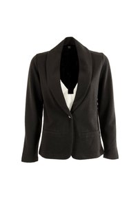 Zwarte blazer van een gestructureerde stof, met schalkraag, enkele knoopsluiting en twee frontzakken. Gelaagd over een witte top.