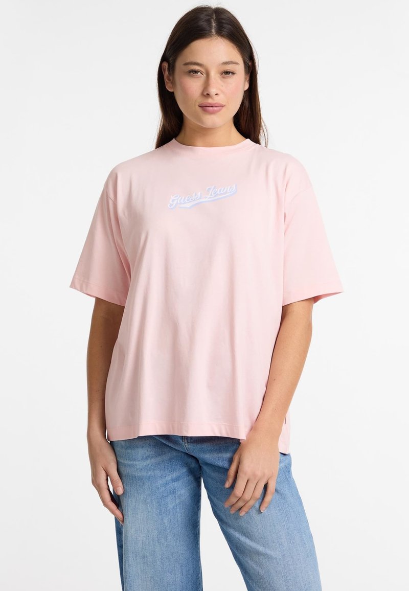 Rozā kokvilnas T-krekls ar apaļu kakla izgriezumu un īsām piedurknēm. Priekšpusē ir izšūts "Guess Jeans" logotips gaiši zilā krāsā.