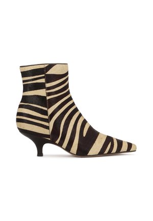 Botte hauteur cheville à bout pointu avec rayures zèbre noires et beige et un talon court et fin sur fond blanc.