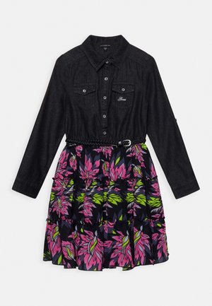 Jeansowa bluzka z długimi rękawami, zapięciem na guziki i dwoma kieszeniami na piersi; spódnica w kwiatowy wzór z falbanami w różu i zieleni na czarnym tle.