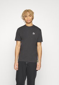 Puma PUMA STAPLE TEE - Apdrukāts T-krekls - puma black
