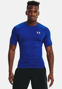 Blauwe sportieve t-shirt met korte mouwen, gemaakt van rekbaar materiaal, aansluitend ontwerp, met het Under Armour-logo in het wit op de linkerkant van de borst.