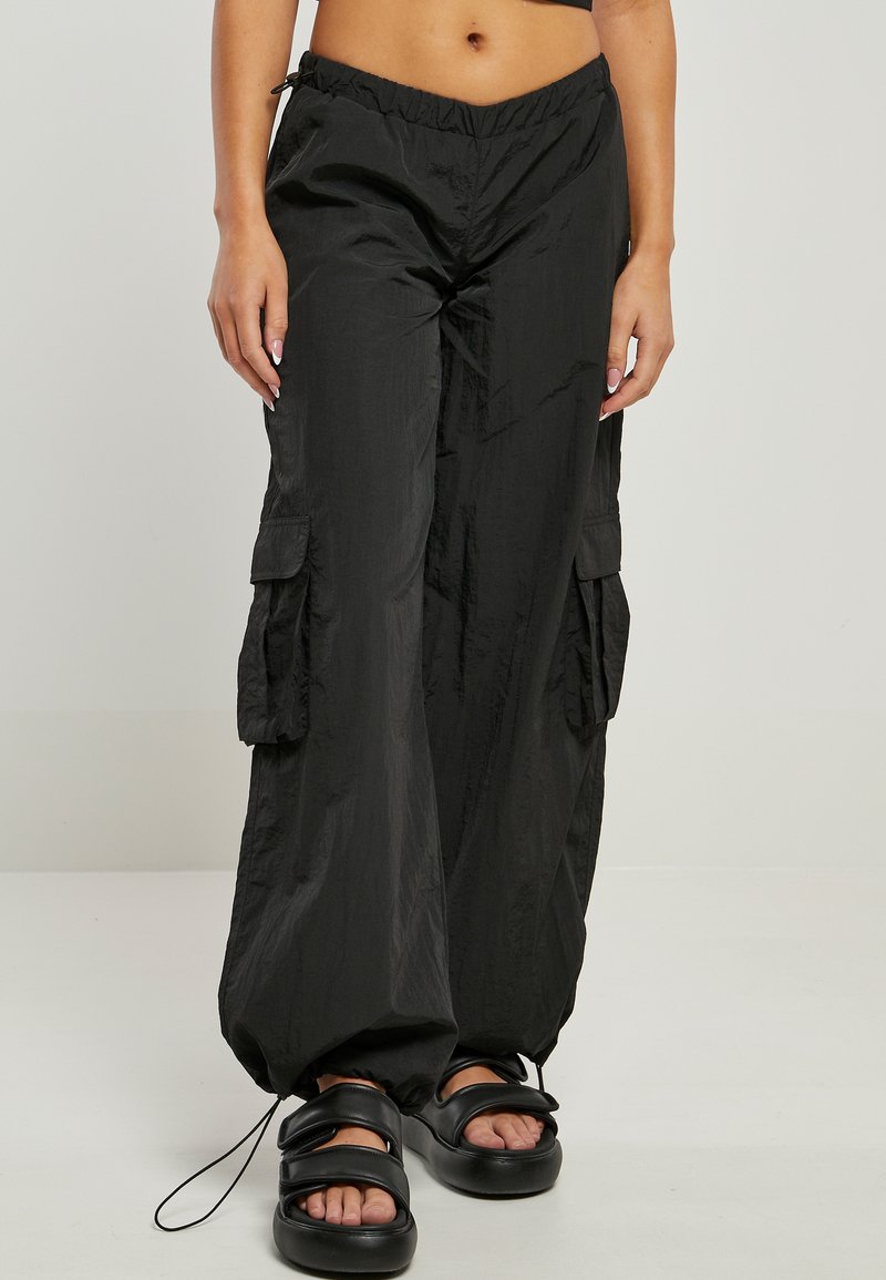 Black wide-leg cargo pants with ankle drawstrings worn with black platform sandals on a standing person.